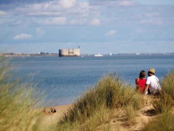 couple en bord de mer qui regarde le fort boyard proche de nos hôtels à la rochelle